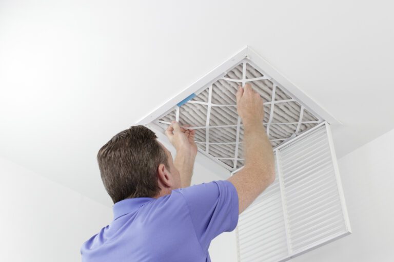 Homeowner in Erlanger, KY, changing home air filter.