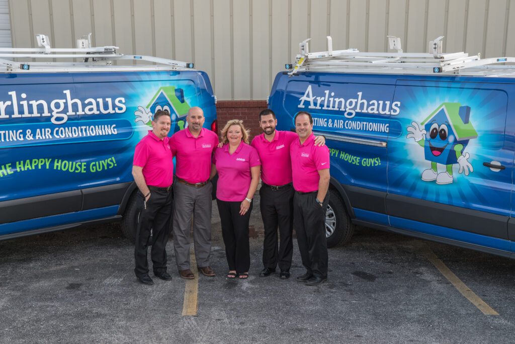 Arlinghaus employees smiling in front of fleet vehicles