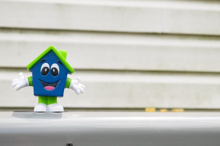 Happy House mascot toy in front of home